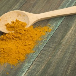 turmeric powder and wooden spoon